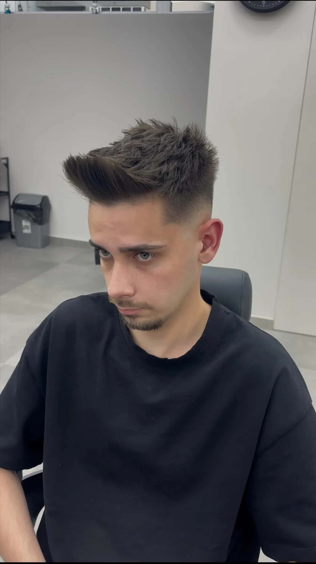 Tânăr cu breton texturat și mid fade, după tuns