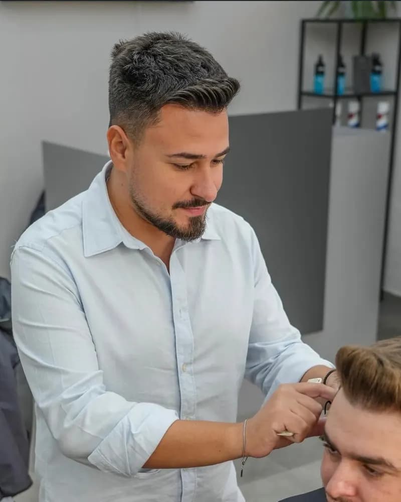 Robert Bușe, fondator R|B Barbershop, tunzând un client