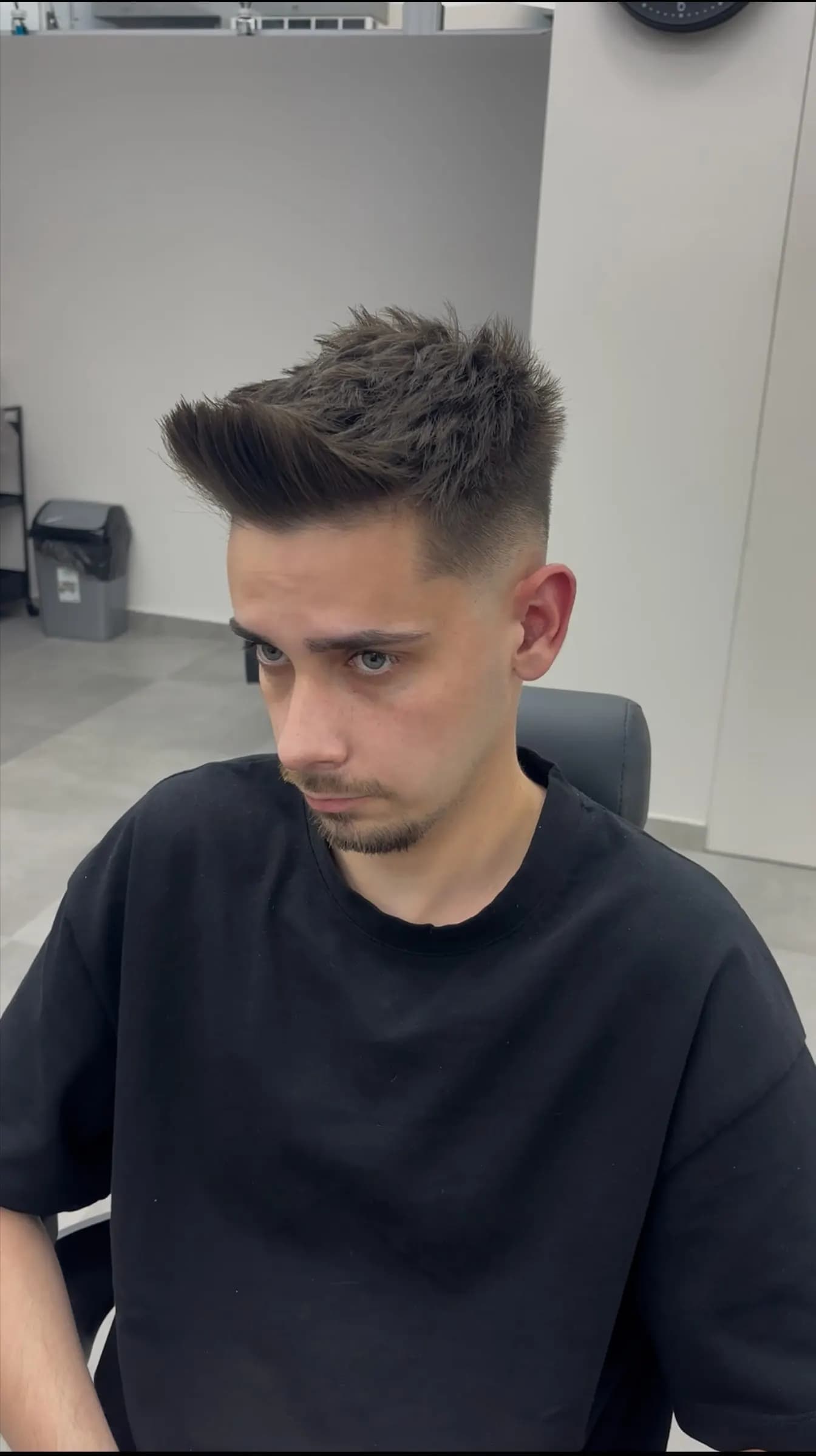 Tânăr cu breton texturat și mid fade, după tuns